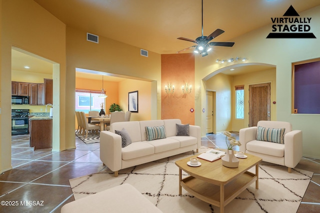 living room with ceiling fan, sink, and vaulted ceiling