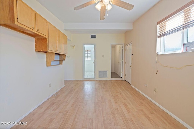 empty room featuring ceiling fan, beam ceiling, and light wood-type flooring