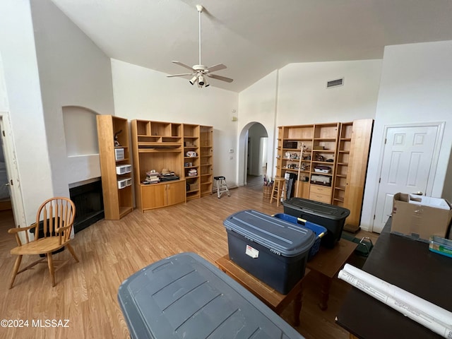 living room featuring ceiling fan, high vaulted ceiling, and wood-type flooring