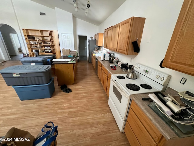 kitchen with light wood-type flooring, stainless steel fridge, electric range, and vaulted ceiling