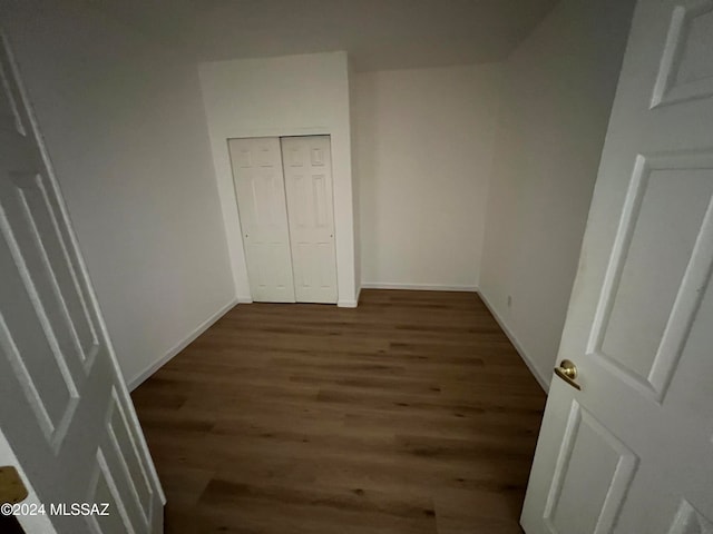 unfurnished bedroom with dark hardwood / wood-style flooring and a closet