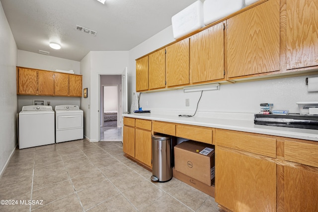 kitchen with light tile patterned floors, washing machine and dryer, and a textured ceiling