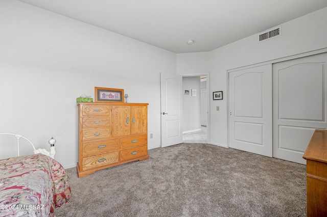 bedroom featuring light carpet and a closet