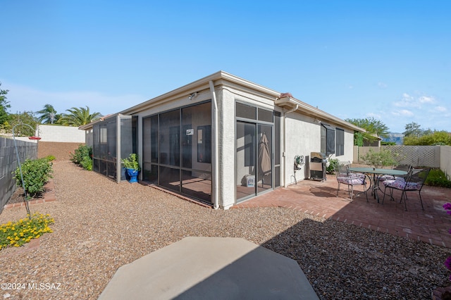 rear view of property with a patio area and a sunroom