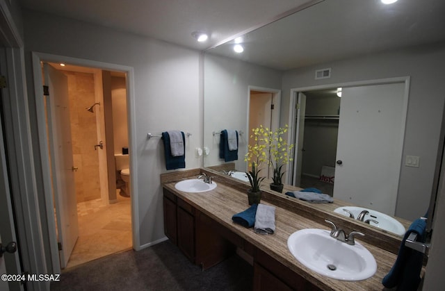 bathroom featuring a shower, vanity, and toilet