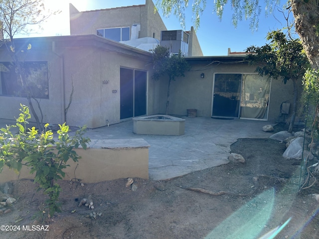 back of house with a fire pit and a patio area