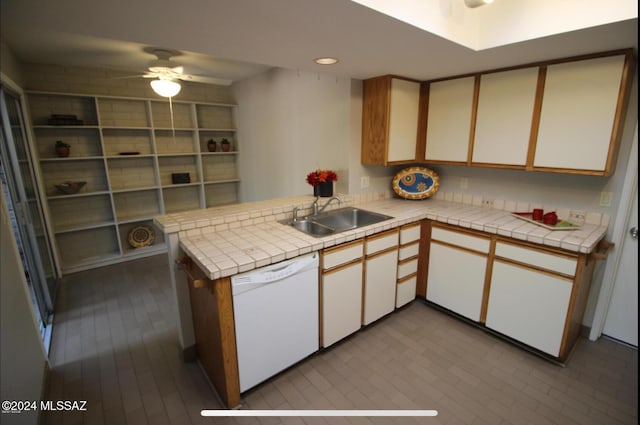 kitchen featuring white cabinetry, sink, tile counters, kitchen peninsula, and white dishwasher