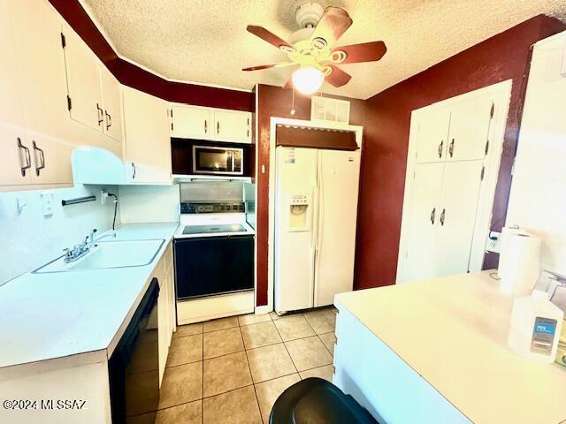 kitchen featuring white cabinets, a textured ceiling, white appliances, and sink