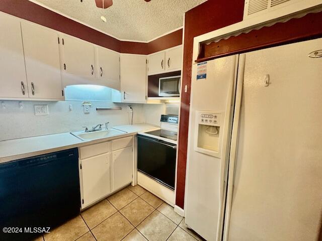 kitchen with ceiling fan, sink, a textured ceiling, white appliances, and white cabinets