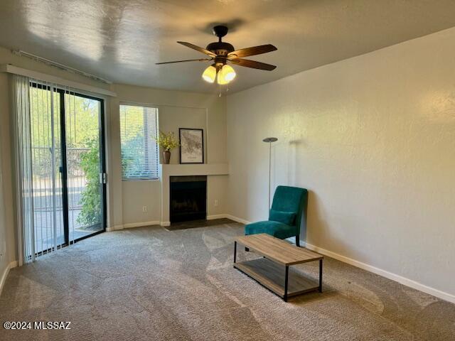 sitting room featuring ceiling fan and carpet