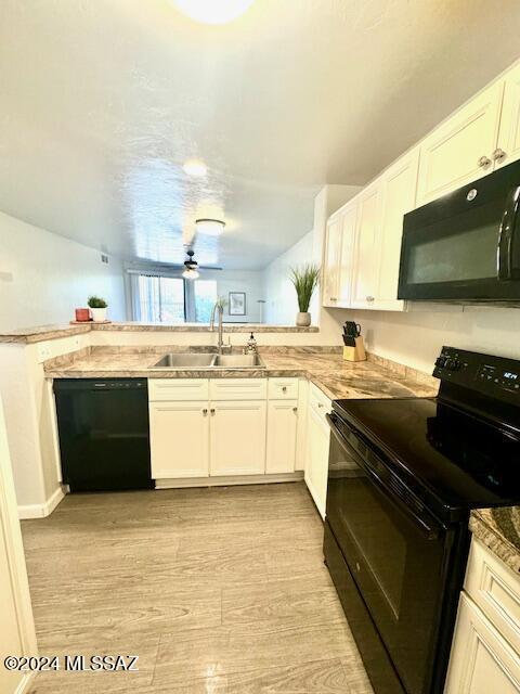 kitchen featuring ceiling fan, sink, light hardwood / wood-style flooring, white cabinets, and black appliances