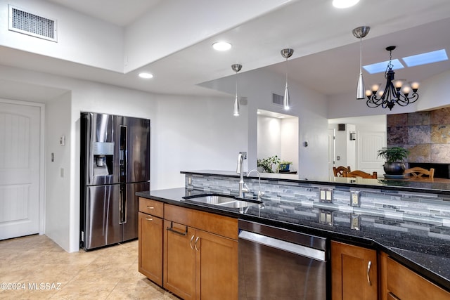 kitchen featuring a sink, visible vents, appliances with stainless steel finishes, backsplash, and brown cabinets