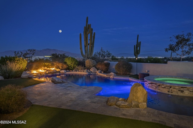 pool featuring an in ground hot tub, a patio, a fenced backyard, and a mountain view