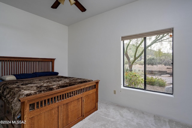 bedroom featuring ceiling fan, multiple windows, and carpet flooring