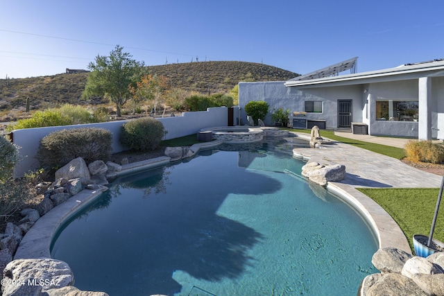 view of pool featuring a pool with connected hot tub, fence, and a patio