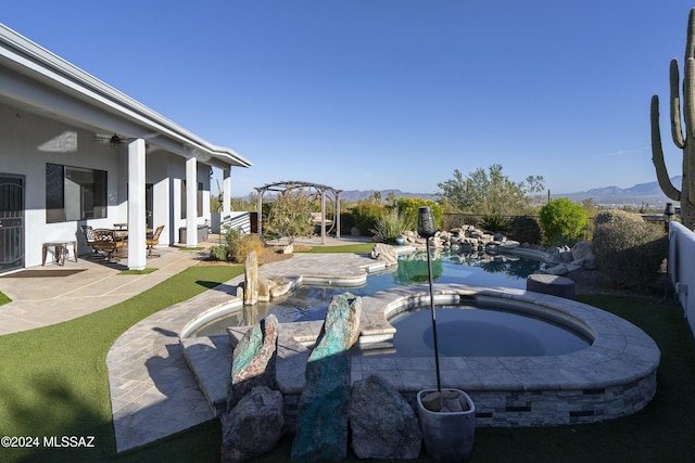 exterior space featuring a ceiling fan, a patio area, a mountain view, fence, and an in ground hot tub