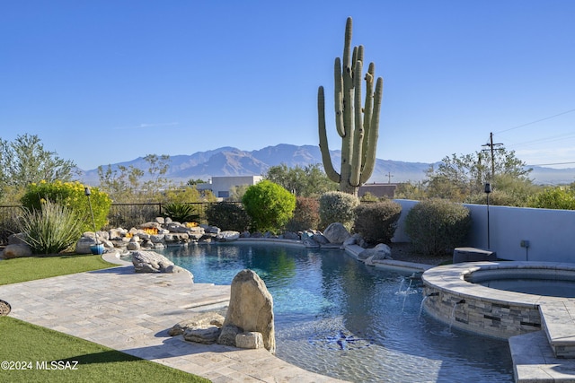 view of pool with a fenced in pool, a mountain view, fence, and an in ground hot tub