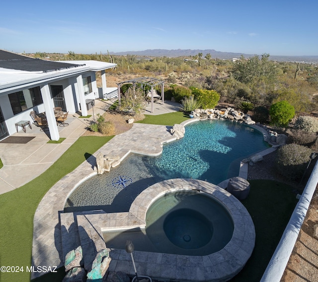 view of swimming pool with a patio, a pool with connected hot tub, a mountain view, and a pergola