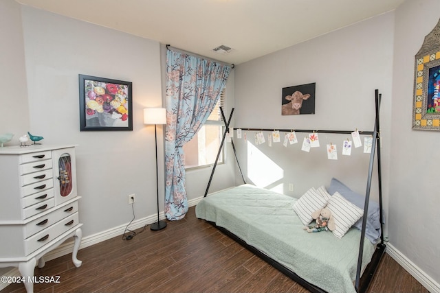 bedroom with dark wood-type flooring