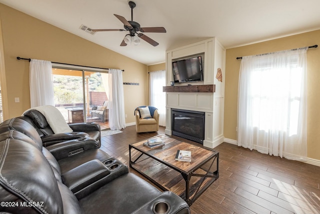 living room with ceiling fan, a healthy amount of sunlight, lofted ceiling, and dark wood-type flooring