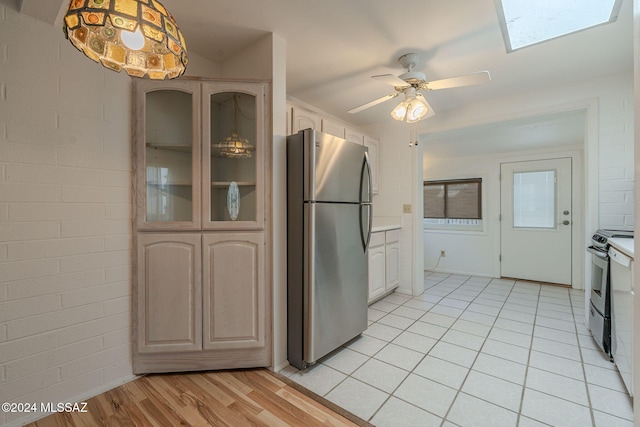 kitchen featuring stainless steel fridge, ceiling fan, white electric range, light hardwood / wood-style floors, and hanging light fixtures