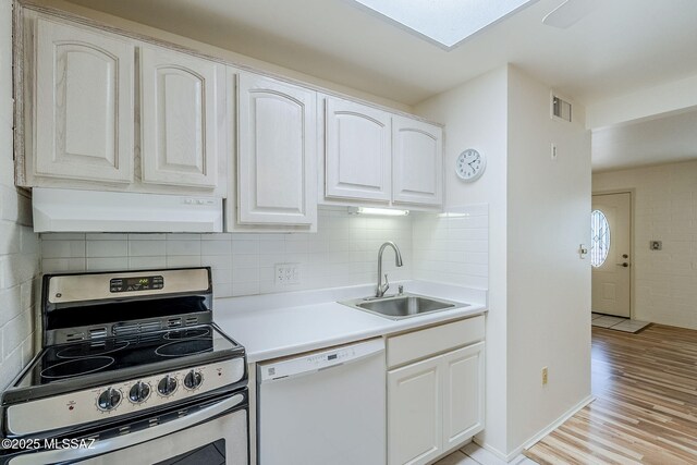 kitchen with stainless steel refrigerator, sink, hanging light fixtures, light hardwood / wood-style flooring, and white dishwasher