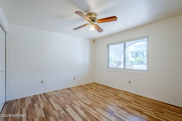 unfurnished bedroom featuring ceiling fan, a closet, and light hardwood / wood-style floors