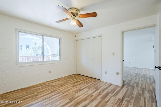 unfurnished bedroom with ceiling fan, light hardwood / wood-style floors, and a closet