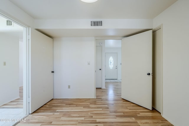 hallway with light wood-type flooring and visible vents