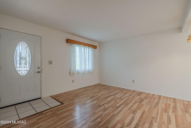 foyer entrance featuring light wood-type flooring and brick wall