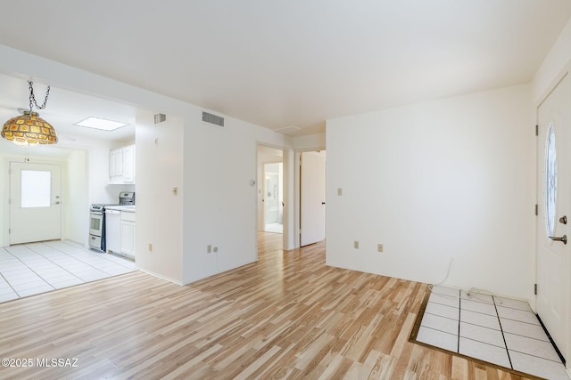 unfurnished living room featuring visible vents and light wood finished floors