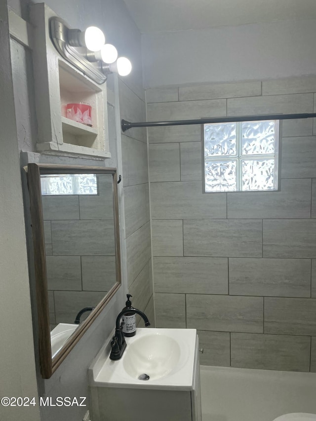 bathroom with vanity, toilet, and a tile shower