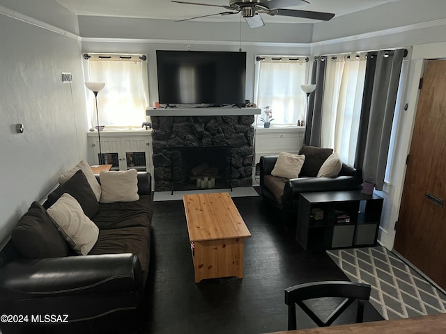 living room featuring ceiling fan, a fireplace, and dark wood-type flooring