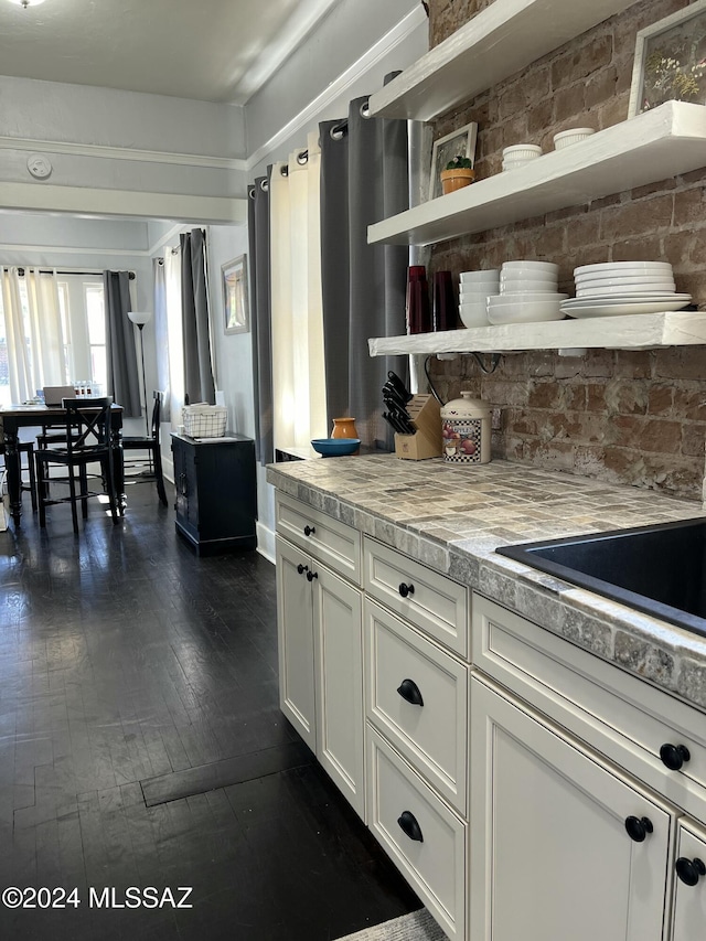 kitchen with white cabinetry, dark hardwood / wood-style flooring, and light stone counters