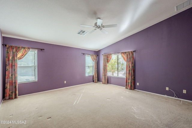 carpeted empty room featuring ceiling fan, a textured ceiling, and vaulted ceiling