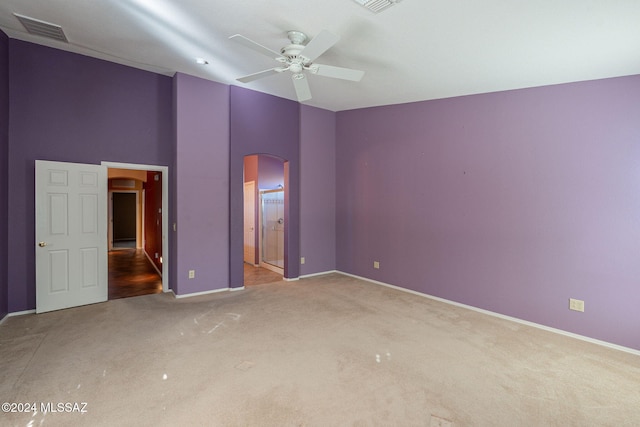 unfurnished bedroom with carpet, ensuite bath, and ceiling fan