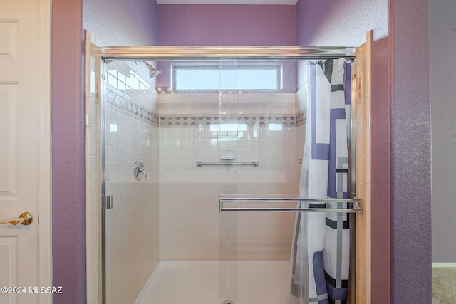 bathroom featuring a shower with door