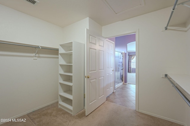 walk in closet featuring light carpet