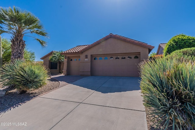 1474 N Miranda Ln, Green Valley, AZ 85614 - mediterranean / spanish-style house with stucco siding, a tiled roof, concrete driveway, and an attached garage