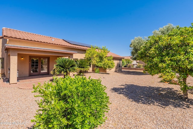 1474 N Miranda Ln, Green Valley, AZ 85614 - back of property with roof mounted solar panels, stucco siding, and a tiled roof