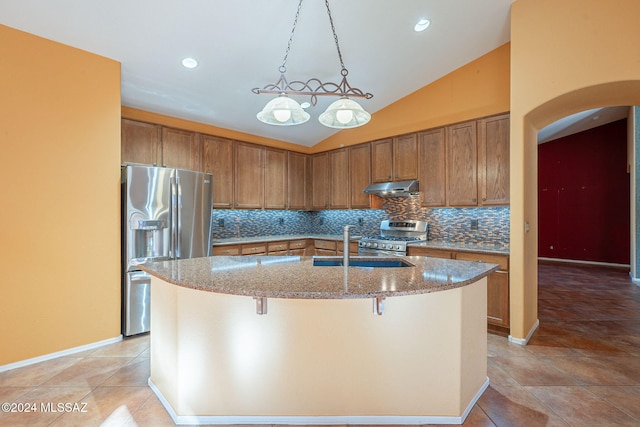 kitchen featuring tasteful backsplash, an island with sink, lofted ceiling, a breakfast bar area, and appliances with stainless steel finishes