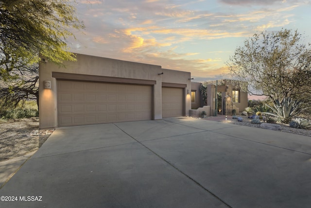 pueblo revival-style home featuring a garage