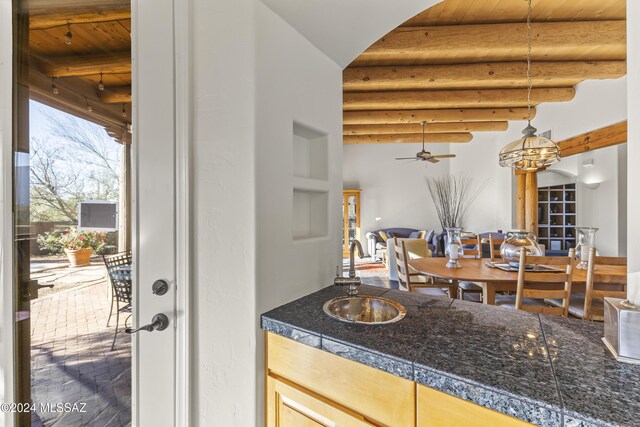 living room with beam ceiling, ceiling fan, and wooden ceiling