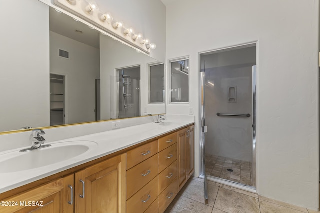 bathroom with tile patterned flooring, vanity, and a shower with shower door