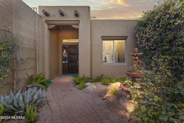 view of exterior entry at dusk