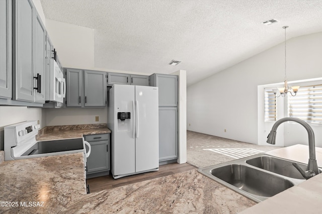 kitchen with sink, white appliances, gray cabinets, and pendant lighting