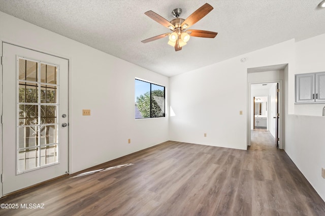 spare room featuring ceiling fan, a textured ceiling, and dark hardwood / wood-style floors