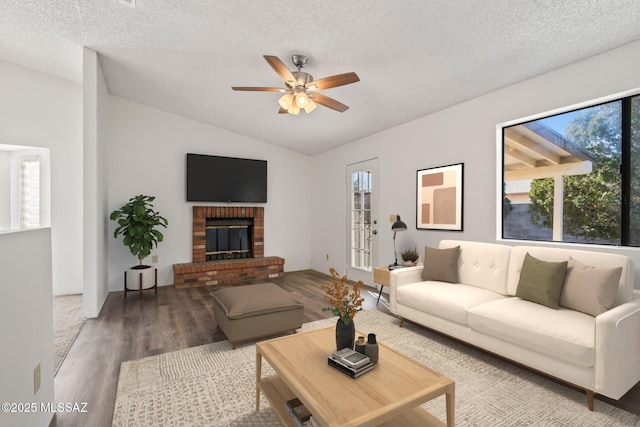 living room with a textured ceiling, a wealth of natural light, and wood-type flooring