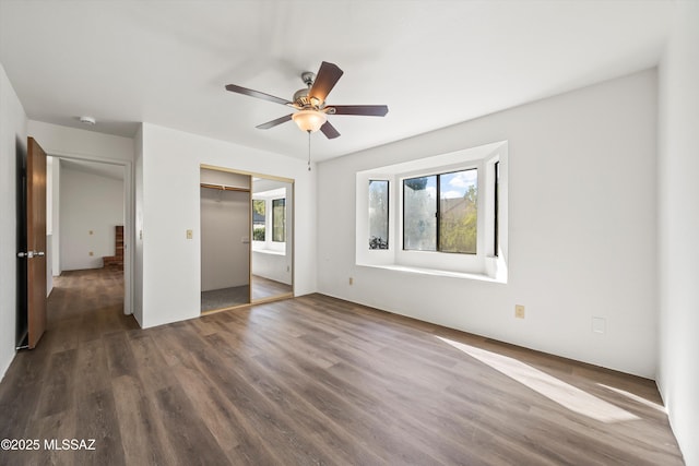 unfurnished bedroom featuring ceiling fan, dark wood-type flooring, and a closet