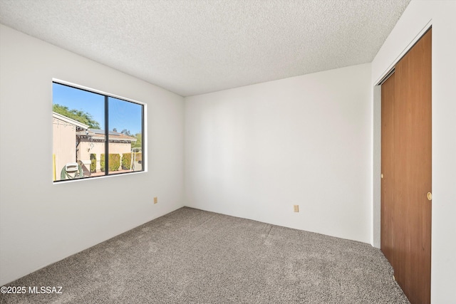 carpeted spare room with a textured ceiling